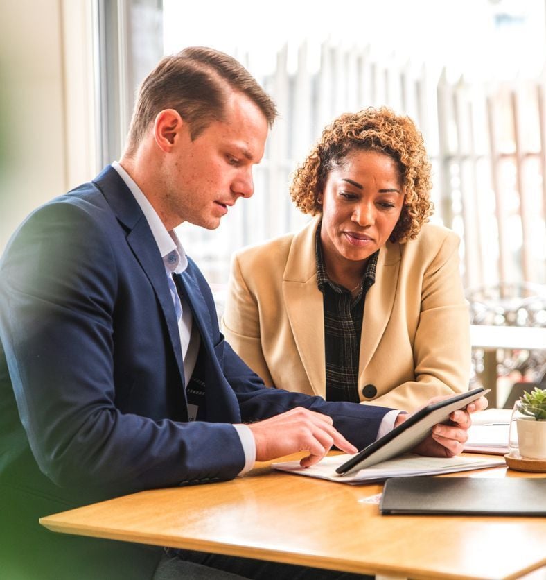 Personal dedicated payment advisor meeting with a merchant reviewing savings and improvements on a tablet, Consulting services in a professional setting