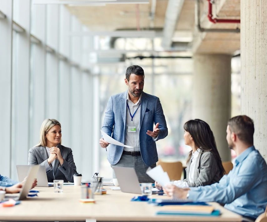 Business leader presenting to a team in a modern conference room, highlighting enterprise partnership strategy with Virtue Payments.